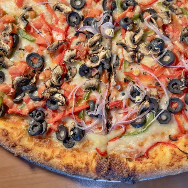 Virgo vegetarian pizza with mushrooms, black olives, red onion, green bell peppers, and tomatoes